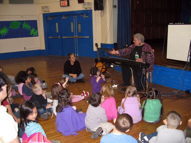 Photo of Ann with kids in school.